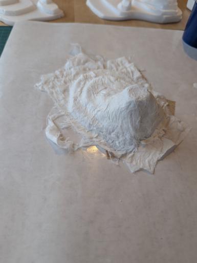 A miniature terrain hill in the making. There is a miniature hill like structure covered with toilet paper soaked in PVA glue and water